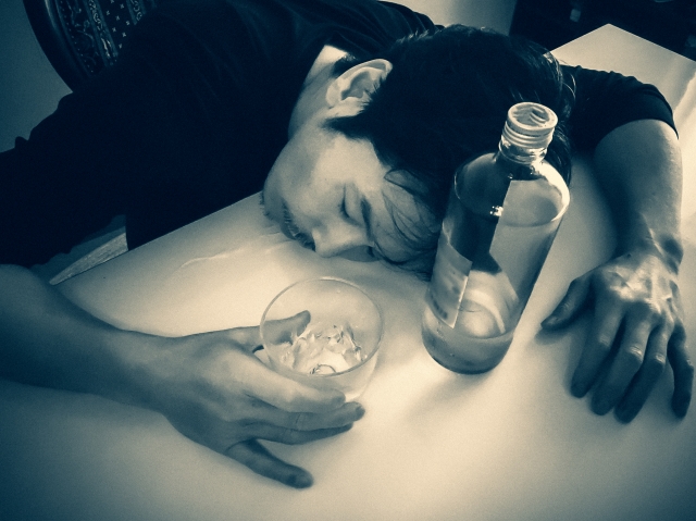 お酒を飲んで寝ている男性の写真