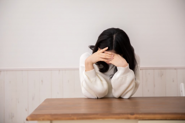 悩んでいる女性の写真